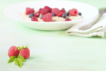 Raspberry with leaves on the wooden table