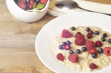 Oatmeal in plate on wooden background