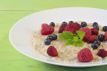 Oatmeal in plate on wooden background