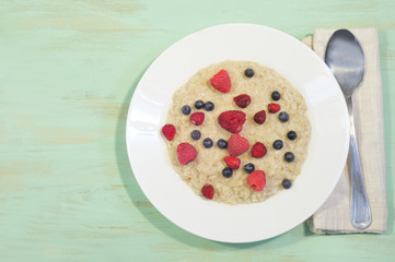 Oatmeal in plate on wooden background