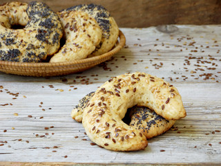 bagels sprinkled with poppy seeds and flax seeds in a basket on a wooden background