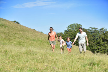 Obraz premium Family on vacation running down the hill