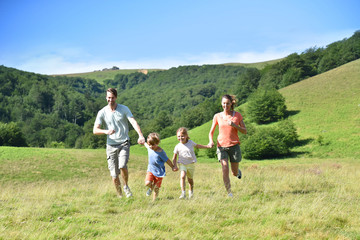 Family on vacation running down the hill