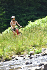 Woman riding bike in mountain field