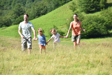 Obraz premium Family on vacation running down the hill