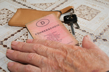 Seniorenhand mit altem Führerschein