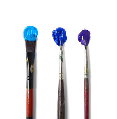 Artists brushes with acrylic paint smears isolated on a white background