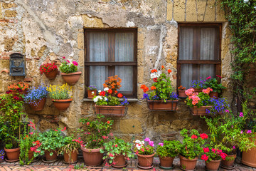 Flower filled streets of the old Italian city in Tuscany. - 115642844