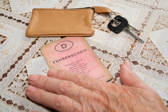 Seniorenhand mit altem Führerschein