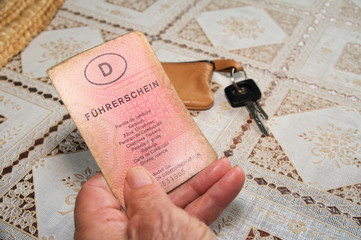 Seniorenhand mit altem Führerschein