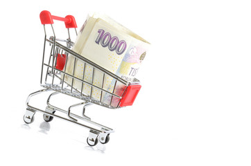 Shopping cart with czech banknotes inside isolated on white background