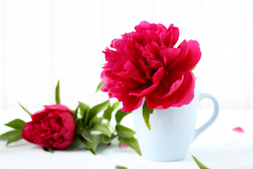 Bouquet of red peony flowers on a white wooden table