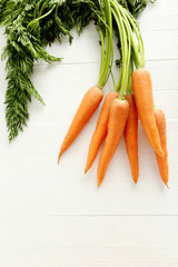 Fresh and sweet carrots on a white wooden table