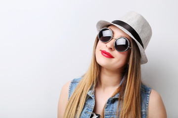 Fototapeta premium Portrait of a beautiful hipster girl on grey background