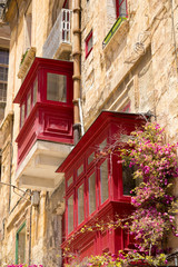 Fototapeta na wymiar Red traditional wooden Maltese balconies in Valletta