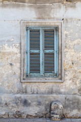 Fototapeta na wymiar Weathered and Ancient Maltese shuttered window , blue