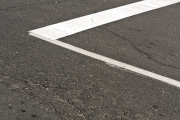 White paint mark on the old asphalt road.