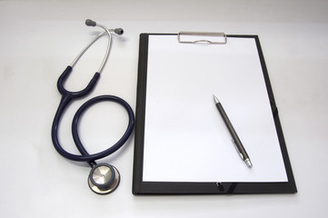 Stethoscope and blank clipboard with a sheet of white paper.