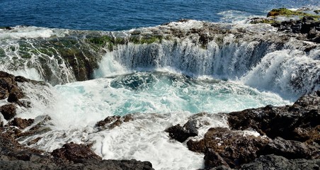Spontaneous waterfall in natural pool at high tide, coast of Telde, Gran canaria, Canary islands