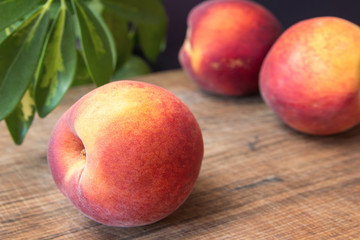 Fototapeta na wymiar Fresh peaches on a wooden cutting board.