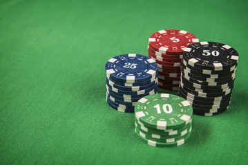 Gambling chips and poker card on green felt background