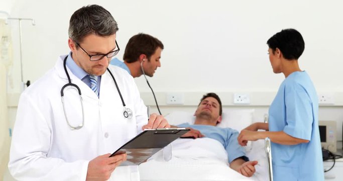 Doctor checking sick patients chart