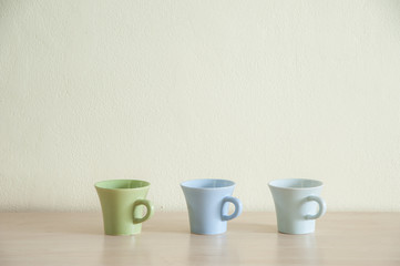 Row of colorful coffee cups on clear background. Top space of frame.