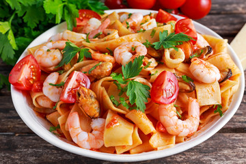 Tasty Pappardelle pasta with shrimp, Squid, mussel, tomatoes and herbs.