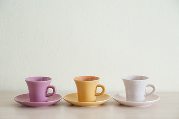 Arrangement pile of colorful modern cups of coffee on wooden table with the coffee dishes for prepare serve..