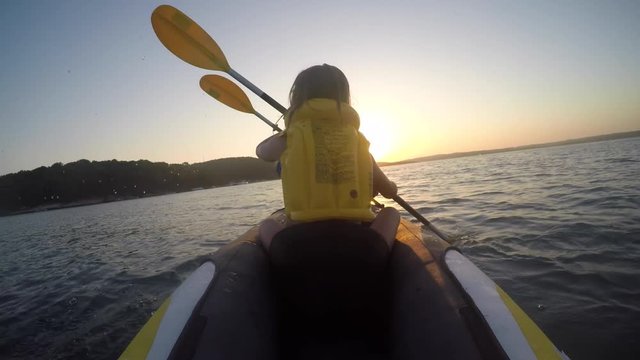 Father and daughter on kayak at sunset