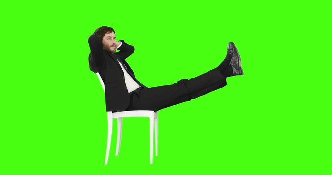 Businessman relaxing on a chair with legs up on green screen