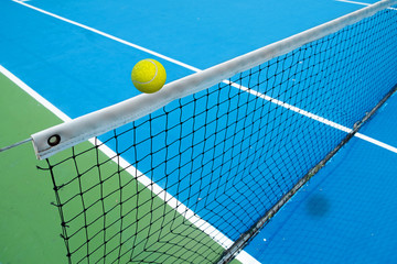 tennis ball crossing net in tennis court