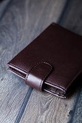 brown leather wallet on wood board background
