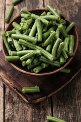 Bunch of freshly picked green beans on a wooden surface.