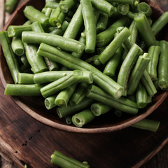 Bunch of freshly picked green beans on a wooden surface.