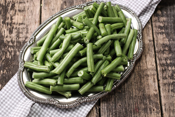 Bunch of freshly picked green beans on a wooden surface.