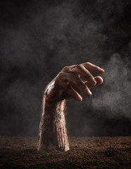 Hand of zombie in blood and dirt
