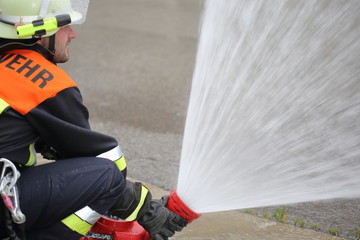 Fototapeta premium Feuerwehrmann mit Hohlstrahlrohr Monitor