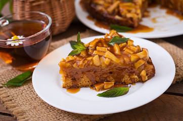 Apple pie with caramel sauce on a wooden background