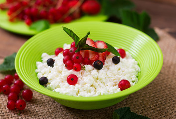 Cottage cheese for breakfast in green bowl on wooden background. Close up