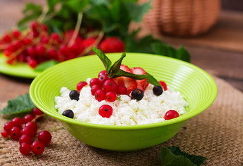 Cottage cheese for breakfast in green bowl on wooden background. Close up
