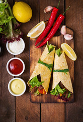 Fototapety  Meksykańskie fajitas na wołowinę i grillowane warzywa (papryka, czerwona cebula, pomidor). Widok z góry
