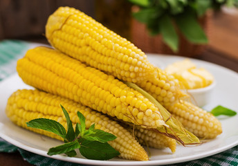 Boiled corn with salt and butter on a white plate