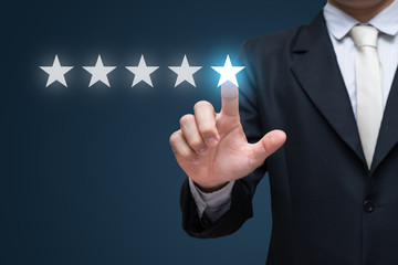 Businessman hand touch five stars on blue background