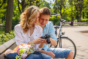 Casual couple using compact dslr photocamera.