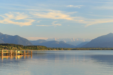 Pier at Chieming Lake Chiemsee at sunset with alpes