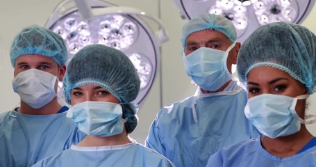 Surgical team looking at the camera in operating theater in high quality 4k format