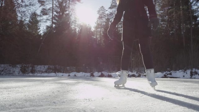 SLOW MOTION CLOSE-UP: Female spinning on ice skates outdoors