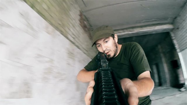 Terrorist hands with rifle moves into an abandoned building