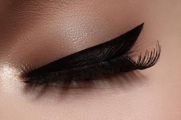 Beautiful macro shot of female eye with extreme long eyelashes and black liner makeup. Perfect...